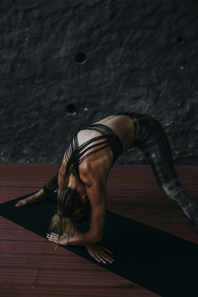 pexels-photo-6146104-6146104 A woman in activewear doing a yoga stretch on a mat indoors, promoting fitness and healthy lifestyle.