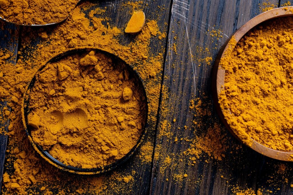 pexels-photo-6220707-6220707 Close-up of turmeric powder in rustic bowls on a wooden surface, ideal for spice and food photography.