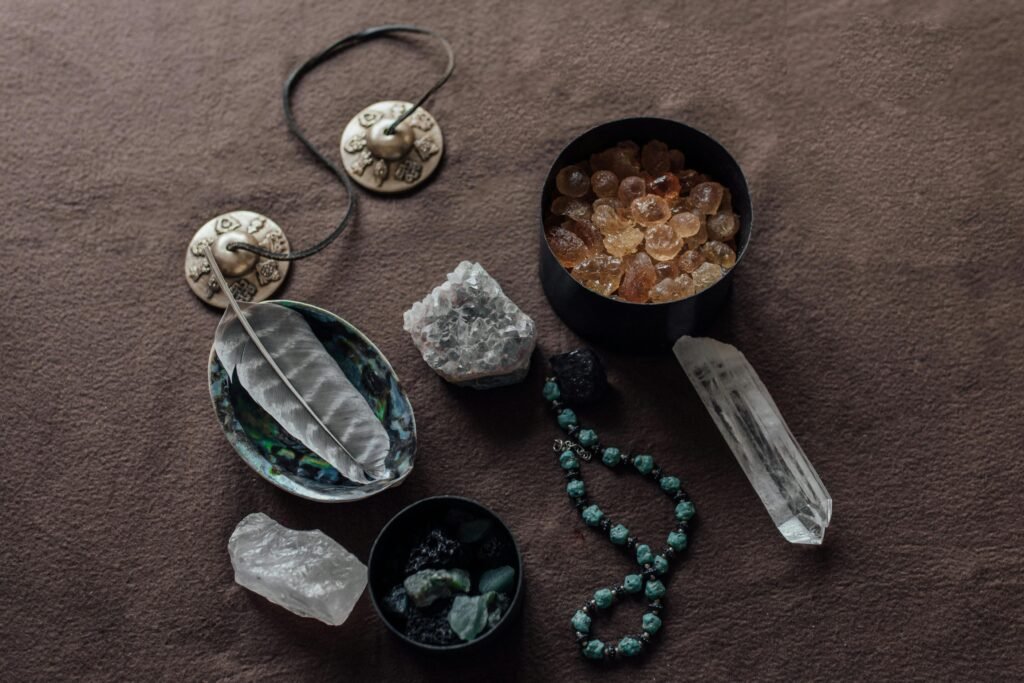 pexels-photo-6998574-6998574 Close-up of spiritual healing crystals and ritual tools on a brown background.
